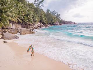 woman on beach drone view from above Seychelles tropical island 