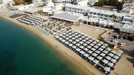 Fototapeta na wymiar Aerial drone bird's eye view photo of famous organized with sun beds emerald clear water beach of Ornos in island of Mykonos, Cyclades, Greece