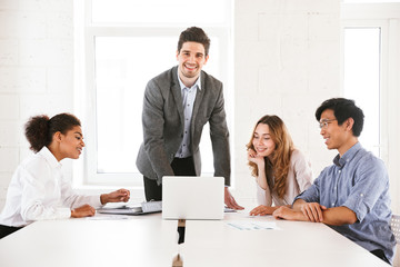 Fototapeta premium Happy young man chief standing at the table