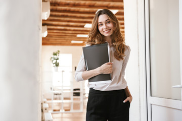 Pretty young business woman holding folder