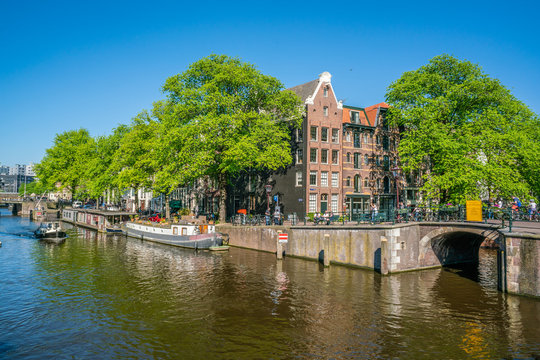 Amsterdam, May 7 2018 - The crossing of the Prinsengracht and the Brouwersgracht  with small boats sailing on it on a sunny day