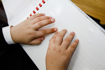 Hand reading the Braille text