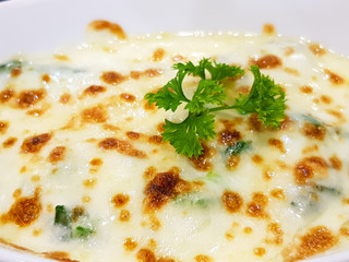 Baked spinach with cheese on white plate background