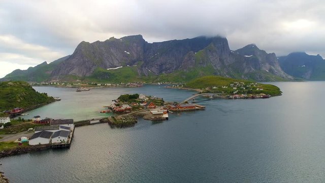 Aerial footage of small fishing village of Hamnoy on Lofoten islands in Norway, popular tourist destination with its typical red houses and natural beauty. Aerial 4k Ultra HD.