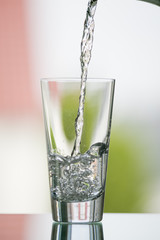 pure,natural freshwater, being poured into a classical trinking glass