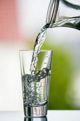 pure,natural freshwater, being poured into a classical trinking glass