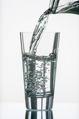 pure,natural freshwater, being poured into a classical trinking glass