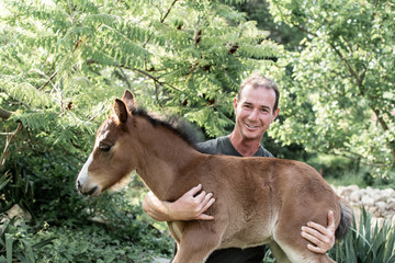 Farmer holding foal.