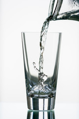 pure,natural freshwater, being poured into a classical trinking glass