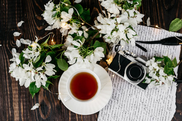 Cup of tea, camera, flowers on the table