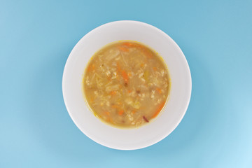 Soup with pasta and vegetables on a blue