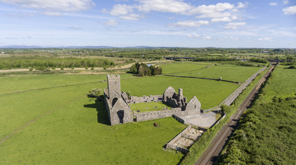 Beautiful aerial birds eye view scenic old ruins of Clare Abbey in County Clare, Ireland. Irish rural countryside with old Irish religious Abbey in decay.