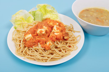 Bolognese spaghetti with tofu on a blue
