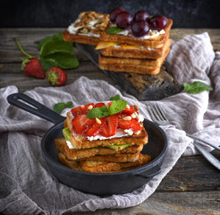 a pile of French toast from white bread with cottage cheese in a black cast-iron round frying pan