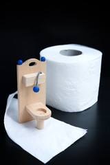 Wooden toy toilet on black background