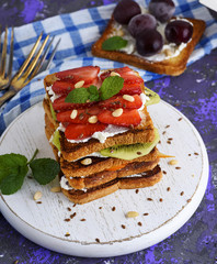 a pile of French toast with cottage cheese, strawberries, kiwi and blueberries