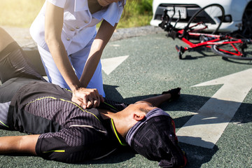 Female nurse helping Emergency CRP on bicycle man in an accident..