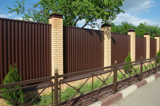 Metal profile fence with brick pillars