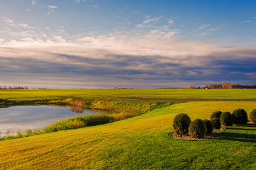 Obraz premium field with lake on sunset in Latvia on cloudy sky background