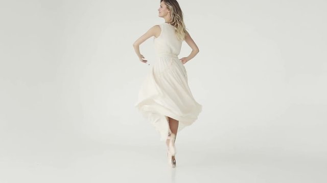 concept of beauty, freshness and youth. ballerina is spinning in a light flying dress on a white background. slow motion