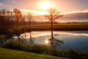 field with lake on sunset in Latvia on cloudy sky background