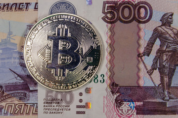 Silver bitcoin on five hundred russian rubles bills background