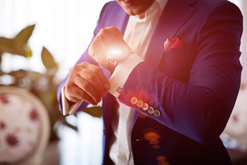 Man wearing luxury cufflinks on shirt. Gathering of groom on wedding day.