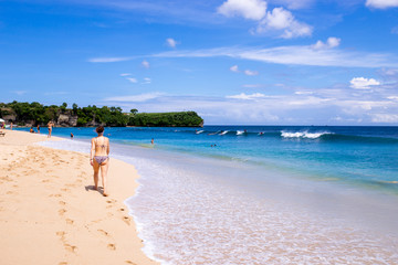 Naklejka premium A woman walking alone on the beach.