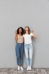 Full length portrait of two cheerful young women