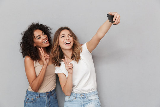 Portrait of two happy young women taking selfie