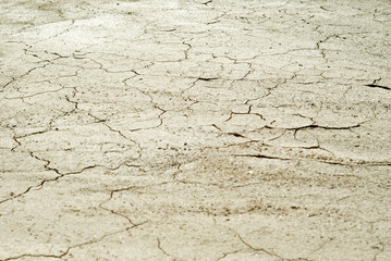 background - cracked dry sun-dried clay crust in a waterless desert