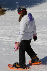 little girl takes steps with snowshoes