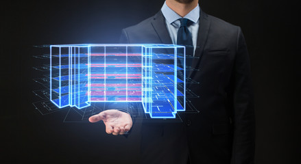 architecture, technology and construction concept - close up of businessman with virtual building blueprint projection