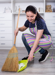 Young mistress sweeping floors