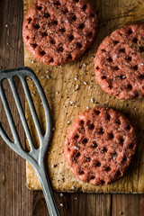 Raw beef burgers on wooden background