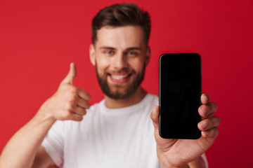 Happy young man showing display of mobile phone make thumbs up gesture.
