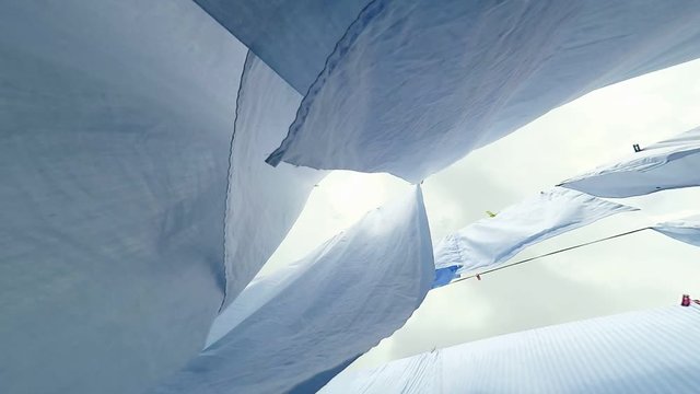 Close-up of white sheets waving in the wind outdoor.