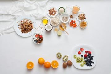 Ingredients for a healthy breakfast - granola, honey, nuts, berries, fruits, top view.
