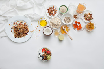 Fototapeta na wymiar Ingredients for a healthy breakfast - granola, honey, nuts, berries, fruits, top view.
