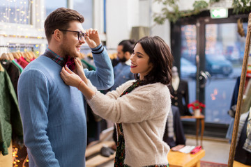 sale, shopping, fashion and people concept - couple choosing clothes at vintage clothing store