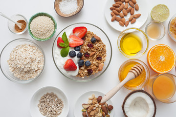 Ingredients for a healthy breakfast - granola, honey, nuts, berries, fruits, top view.