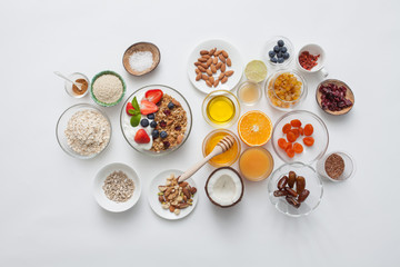 Ingredients for a healthy breakfast - granola, honey, nuts, berries, fruits, top view.