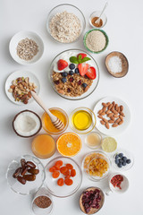 Ingredients for a healthy breakfast - granola, honey, nuts, berries, fruits, top view.