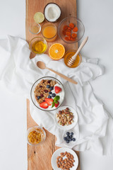 Ingredients for a healthy breakfast - granola, honey, nuts, berries, fruits, top view.