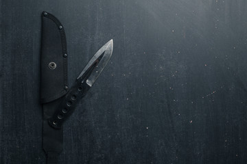 Black tactical knife on black background. Military.