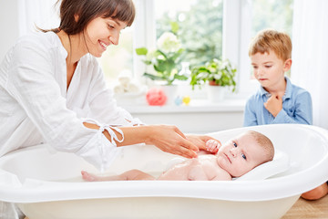 Fürsorgliche Mutter badet ihr Baby
