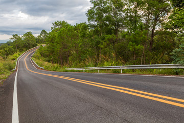 Beautiful mountain asphalt road with curve and double yellow line ,  road runs along the edge of the forest in chiang mai, Thailand
