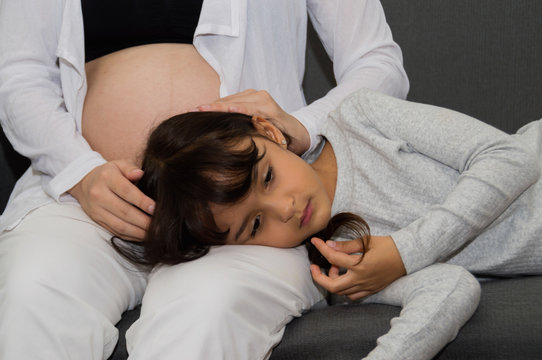 .The girl is listening to belly of pregnant  mother