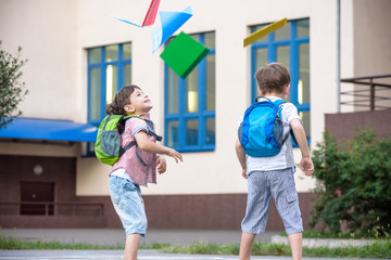Happy children - two boys friends with books and backpacks on the first or last school day.