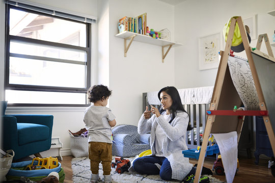 Mother teaching sign language to son at home